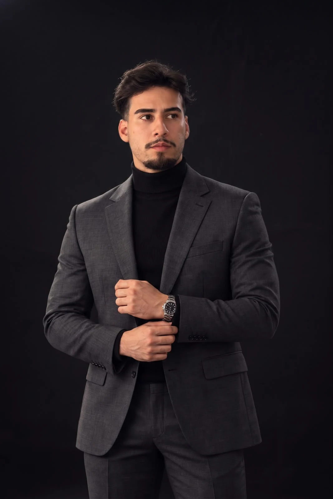 Advogado Wesley Paula de blazer cinza e gola alta, ajustando o punho
